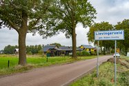 Ingangsweg van Lievingerveld. Het buurtschap wordt aangeduid met een wit plaatsnaambord in blauwe letters. 