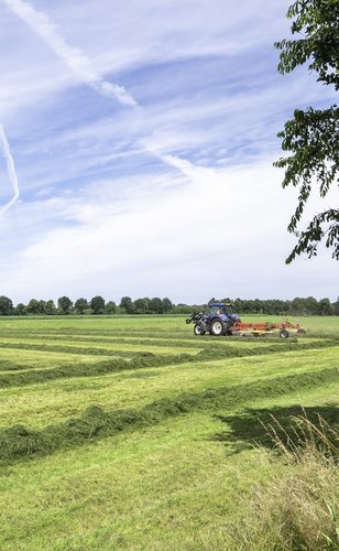 Platteland met een machine die gras maait