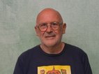 Feiko Kuiper. Hij is kaal, heeft een stoppelbaard en draagt een bril. Hij draagt een t-shirt met een robotachtig poppetje erop dat juicht.