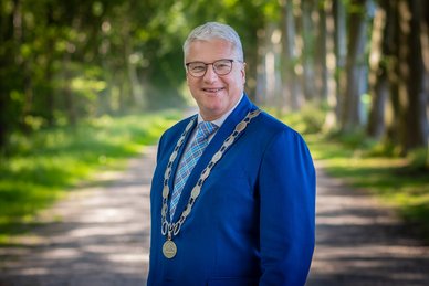 Foto van burgemeester Jan Zwiers. Hij draagt een ambtsketen.