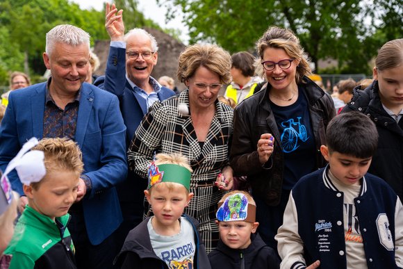Kinderen en bestuurders gooien versierde steentjes in de betonvloer van de nieuwe school Kinderen en bestuurders gooien versierde steentjes in de betonvloer van de nieuwe school