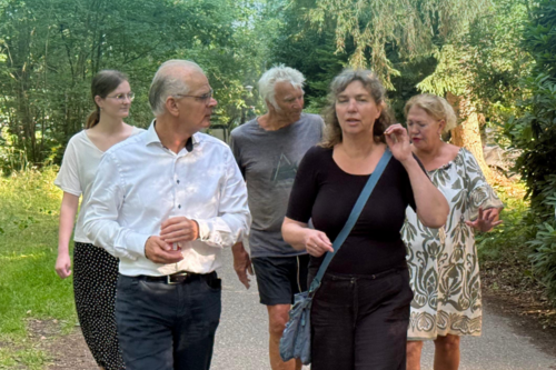 Wethouder Peter Smit loopt met meerdere bewoners over het vakantiepark